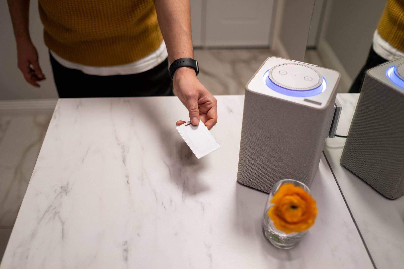 A person using a smart speaker on a kitchen counter