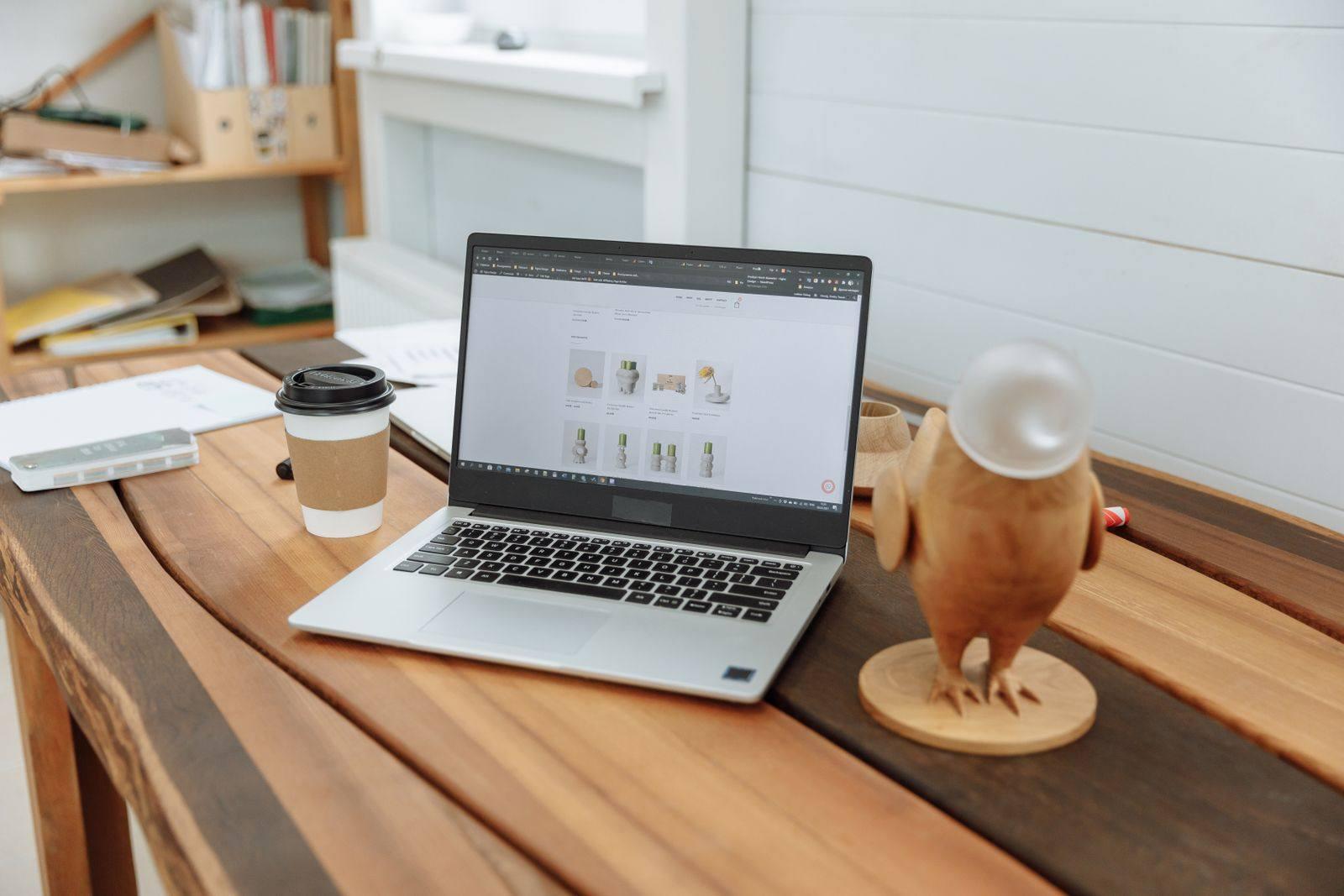A laptop showing a business website on a wooden desk